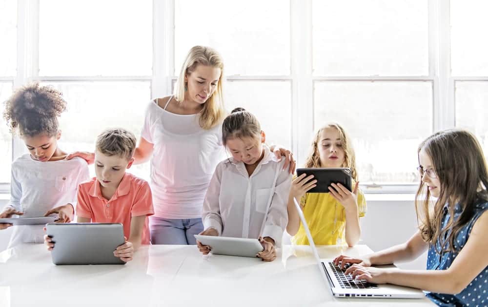Multiple kids on laptops and tablet computers